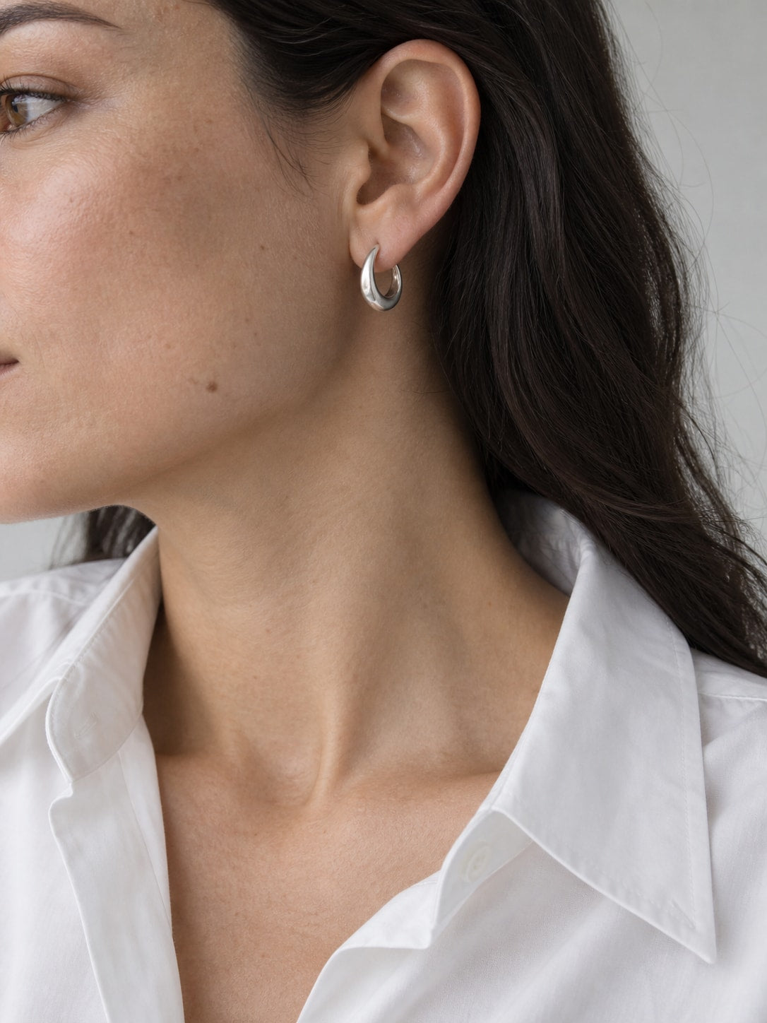 Sculptural silver earrings worn close to the ear